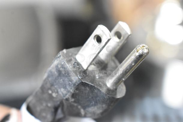 Power plug of a 2016 Hobart HTi-7LH Metal Countertop Scale, 120/208-240 Volts, 1 Phase. Close-up view showing prongs.