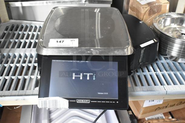 2016 Hobart HTi-7LH metal countertop scale with label printer, touchscreen display, version 3.5.0. Model HTi, 120/208-240 Volts.
