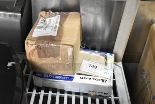 Cardboard boxes labeled "Midland" and "Robertshaw" on metal shelving, sealed with tape, minor dents visible.