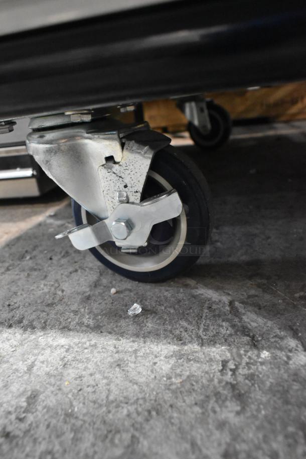 Wheel of the BRAND NEW 2024 Cooking Performance Group SlowPro CHSP1SM Oven, showing sturdy stainless steel construction.