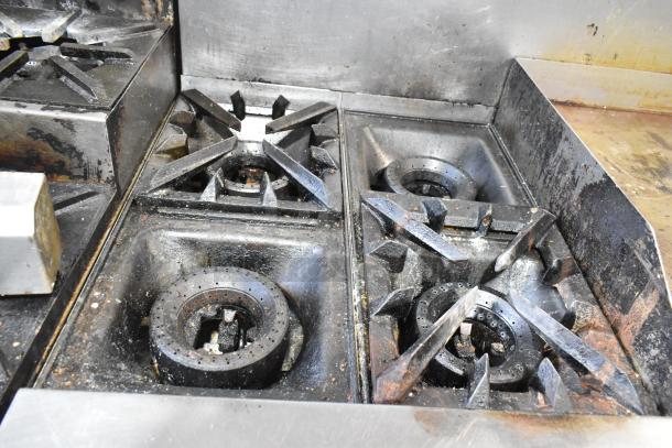 Vulcan V2BG4TS stainless steel commercial griddle with 4-burner range, oven, and backsplash. Features visible wear.