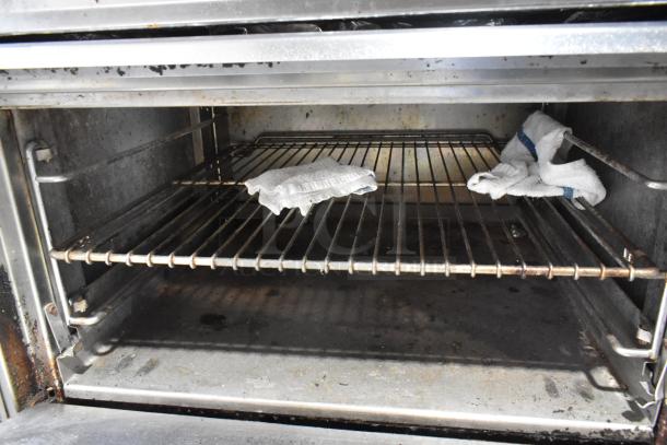 Stainless steel commercial gas griddle with 2-tier 6 burner range, oven, backsplash, on casters, 50,000 BTU, interior view.