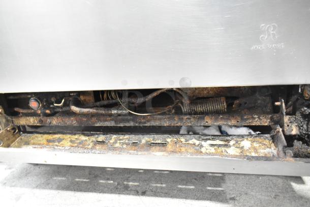 Stainless steel commercial griddle and 6-burner range with oven, visible Jade Range marking, on casters, shows wear.