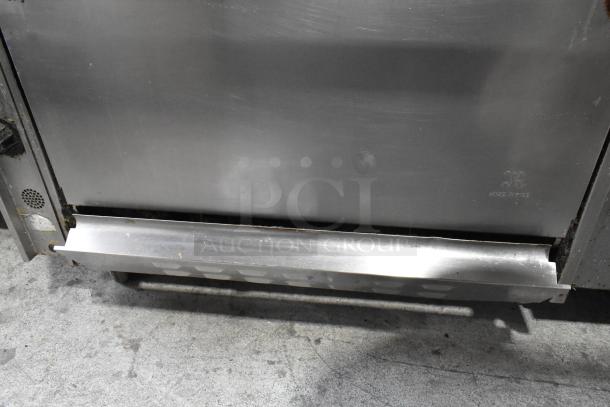 Stainless steel commercial natural gas griddle with 6-burner range, oven, and backsplash on casters, 50,000 BTU.