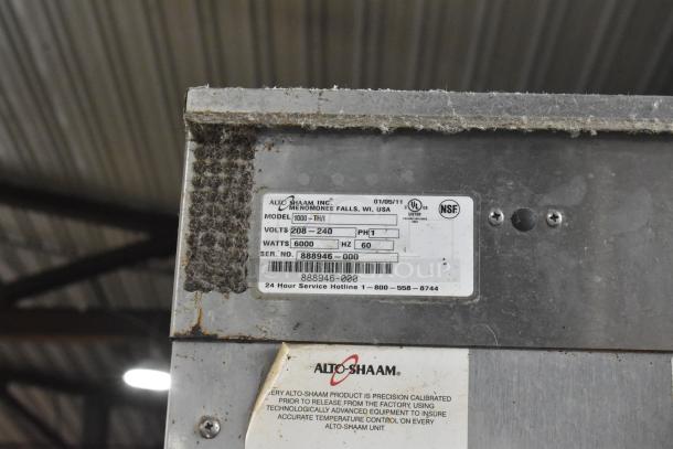 Alto Shaam 1000-TH/I stainless steel oven label, showing model, voltage, and certification. Slight wear visible.