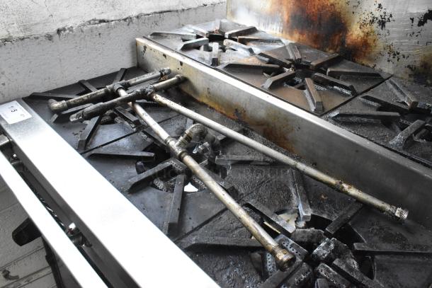 Montague stainless steel commercial gas griddle with 2-tier 6 burner range, oven, and backsplash on casters, 50,000 BTU.