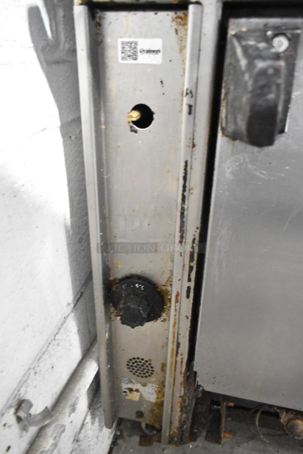 Montague stainless steel griddle with 2-tier 6 burner range. Natural gas powered, 50,000 BTU, on casters. Well-used condition.