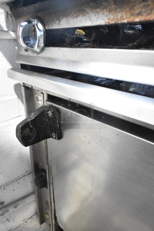 Montague stainless steel commercial griddle with flat top, 2-tier 6 burner range, oven, and backsplash on casters, 50,000 BTU.