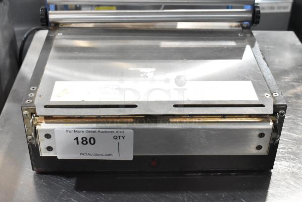 Kopak 4106-1000 metal shrink wrapper, 110V, 1 phase. Visible wear, rectangular design with metal finish, auction label reads "180."