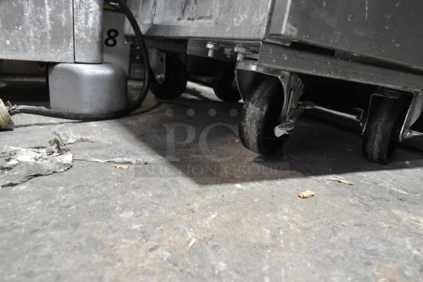 Hangzhou ENFF300L stainless steel fryer on casters, 90,000 BTU, propane gas powered, shown from below on a concrete floor.