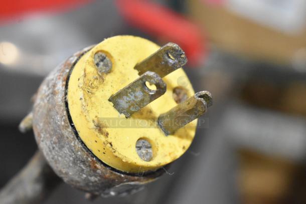 Close-up of a three-prong plug on a Biro 11 metal commercial meat saw, showing signs of wear with rust on metal prongs.