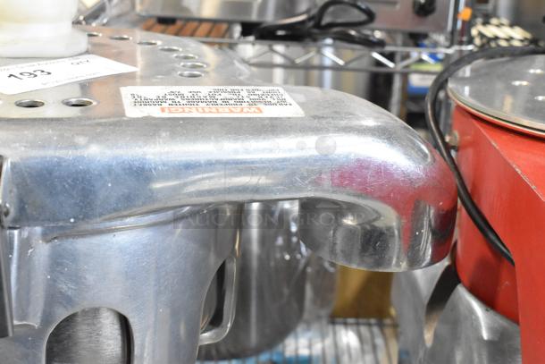 Stainless steel commercial countertop juicer, 115 volts, 1 phase. Visible label with warning text. Excellent condition.