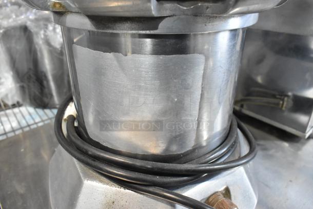 Stainless steel commercial countertop juicer, 115 volts, 1 phase. Features visible wear and electrical cord.