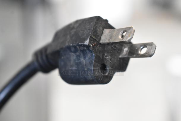 Close-up of a three-prong power plug, showing signs of wear, for the Green World CRT-77-1R cooler. 115 Volts, 1 Phase.