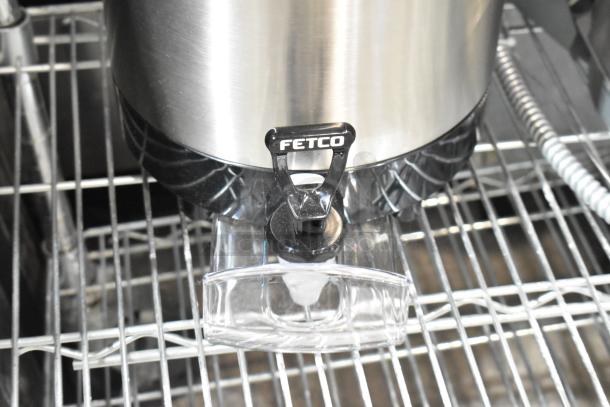 Brand new Fetco Luxus L4S-15, 1.5-gallon stainless steel coffee server with minor scratches, featuring Fetco branding.