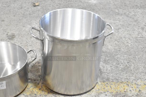 Two stainless steel stock pots, brand new with scratch and dent, featuring sturdy handles, auction label visible.