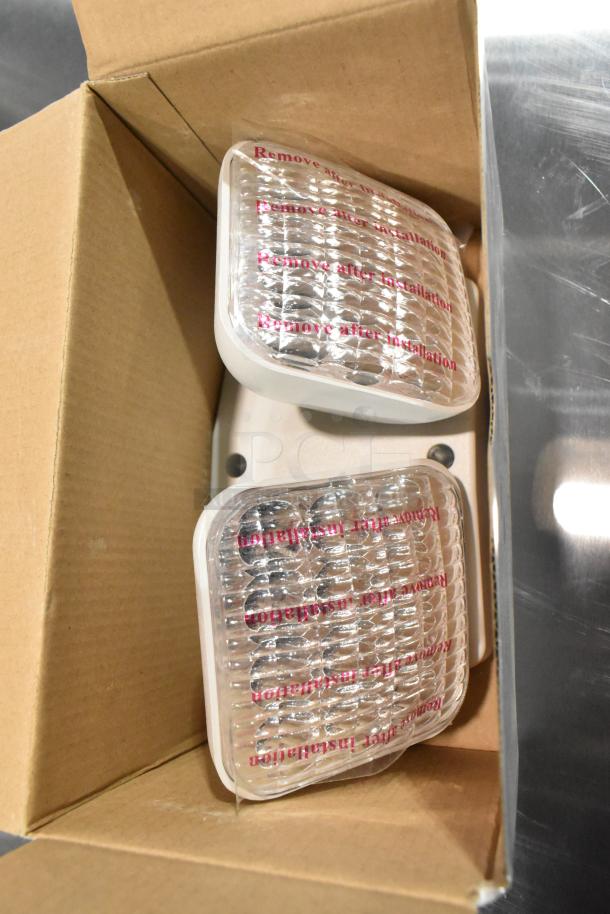 8 brand new ASRLED-2-HL emergency lights in box, model E185721-B, with protective labels intact. Scratch and dent condition.