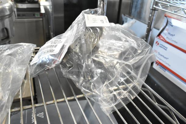 4 brand new scratch and dent items, including Avantco microswitch sleeve, Blodgett spring holder, Garland burner head, and Hatco temp control kit, in sealed packaging on a shelf.