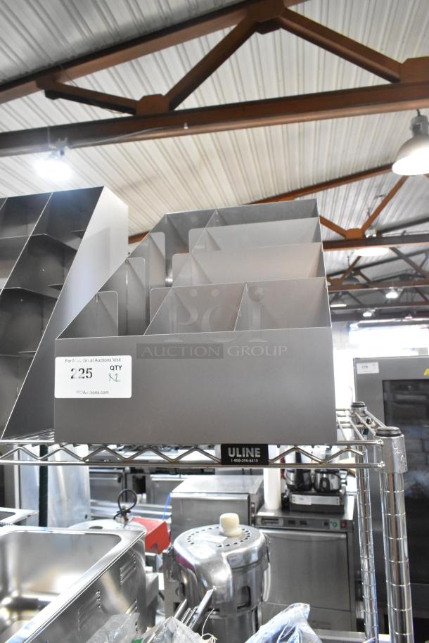 Two brand new metal lid organizers with multiple compartments. Labels indicate "225" and "QTY X2" on a shelf in a warehouse.