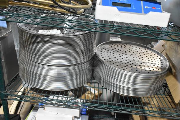 22 Hobart HL80B metal round perforated baking screens, new scratch and dent condition. Multiple stacks on shelf.