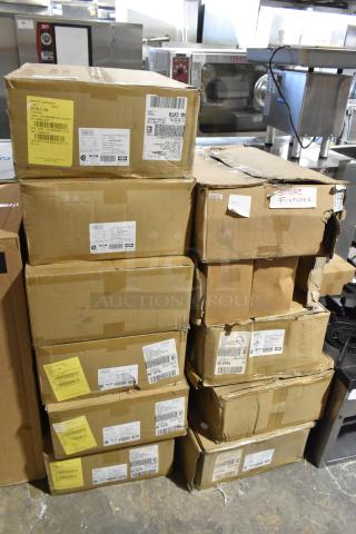 11 boxes labeled "Dual Lite EVHC6IDP-WM" LED emergency lights, new in scratch and dent condition, with various shipping labels.