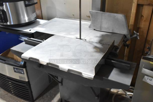 Hobart metal commercial floor meat saw in good condition, features sturdy metal construction with a large cutting surface.