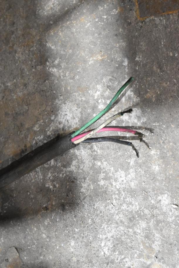 Frayed electrical wires on concrete, possibly from a Hobart meat saw, indicating repair needs before use.