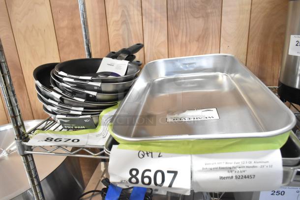 11 new scratch and dent items, including Vollrath 4457 roasting pan and 692408 non-stick fry pans, on metal shelf.