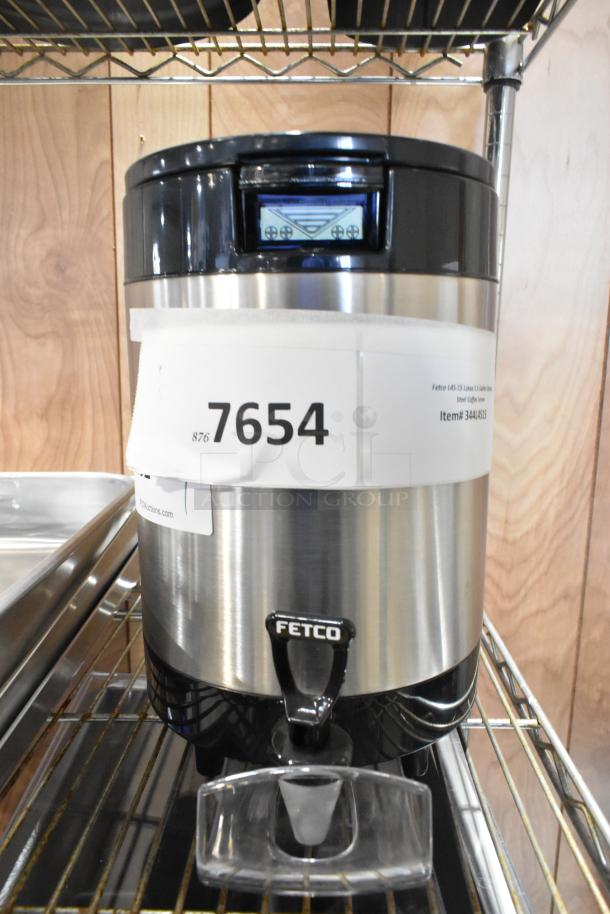 Brand new Fetco L4S-15 Luxus 1.5-gallon stainless steel coffee server, slight scratches, auction tag visible.