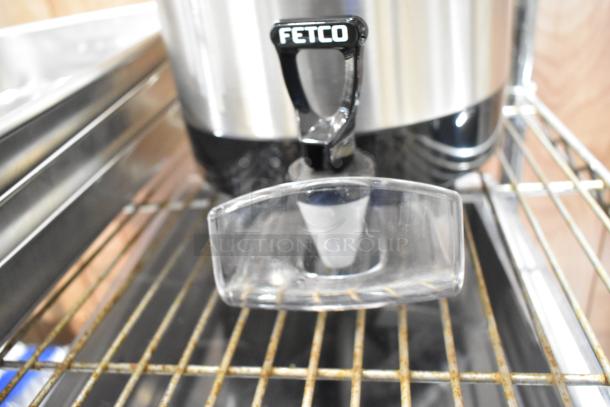BRAND NEW FETCO L4S-15 Luxus 1.5-gallon stainless steel coffee server, minor scratches and dents visible.