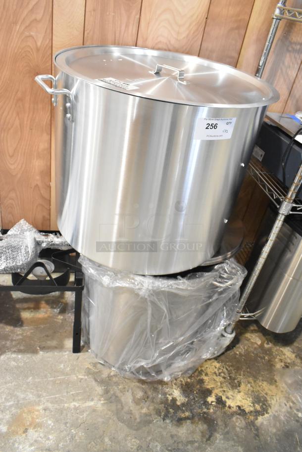 Brand new stainless steel stock pots with lids, scratch and dent condition. Auction label visible, includes two pots.