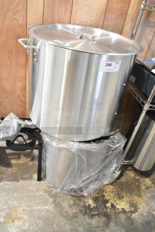 Brand new stainless steel stock pots with lids, scratch and dent condition. Auction label visible, includes two pots.