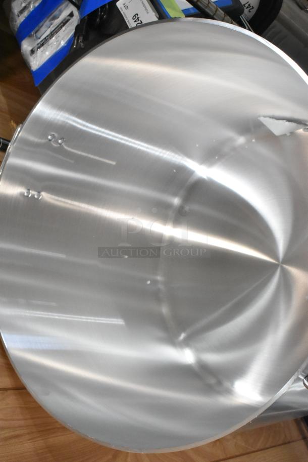 Brand new stainless steel stock pot with lid, minor scratches, polished finish, ideal for kitchen use.