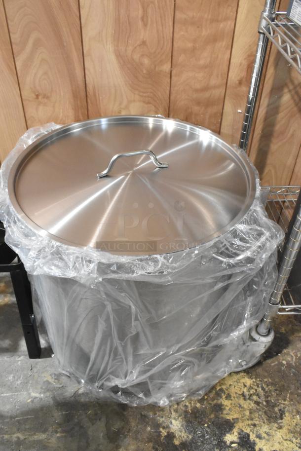New stainless steel stock pot with lid, wrapped in plastic. Scratch and dent condition. Auction: 2 times your bid.