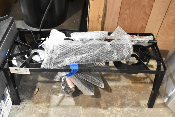 Brand new propane gas 2-burner range, metal, labeled "257." Wrapped in bubble wrap, minor scratches noted.