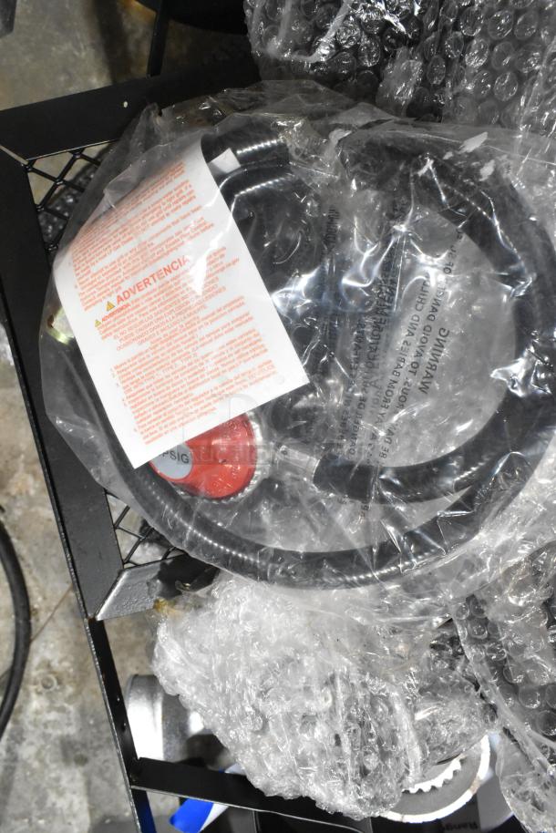 Brand new metal propane gas 2-burner range wrapped in bubble wrap with visible warning label. Condition: Scratch and dent.