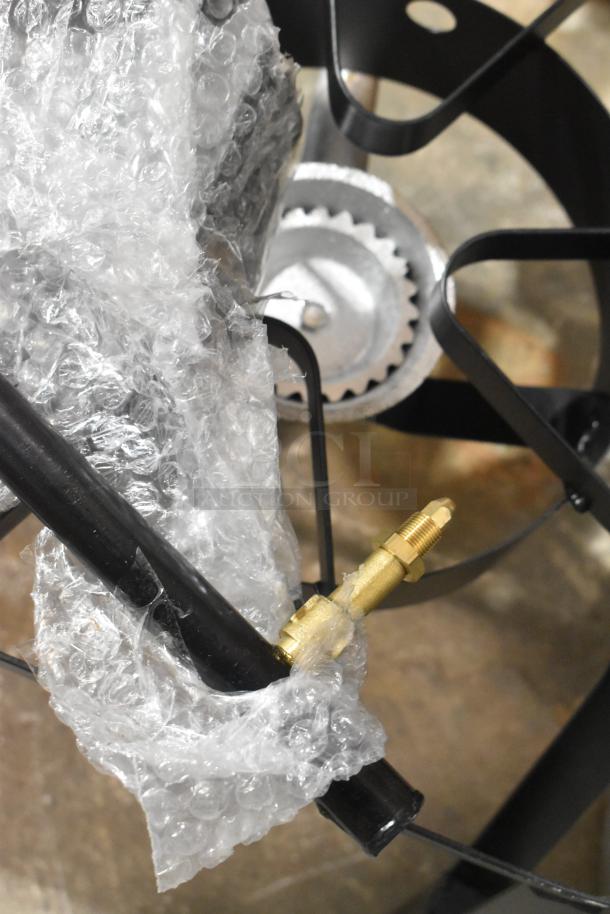 Brand new metal propane gas 2-burner range, partially covered in bubble wrap. Features scratch and dent condition.