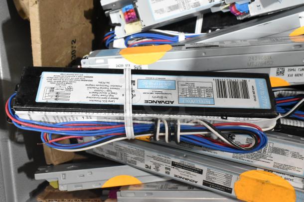 Brand new scratch and dent metal drawer with various Advance ballasts, model numbers visible, intact wiring, minor exterior blemishes.