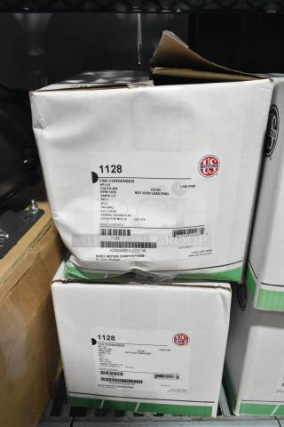 Two US Motors 1128 Fan Condenser Motors in boxes. 460 Volts, 3 Phase. Labels specify model and specifications.