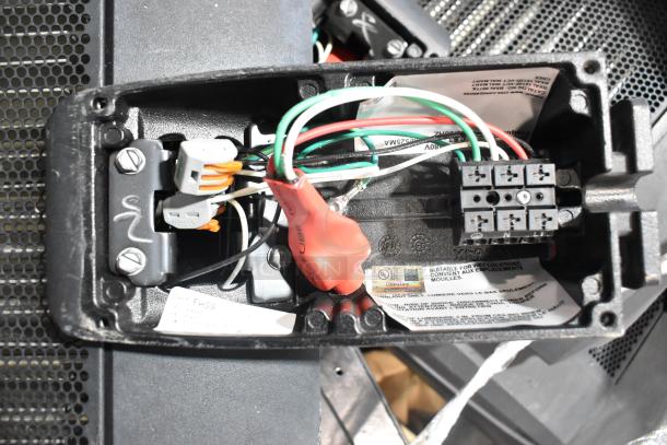 Electrical component inside light fixture with visible wiring and labeled industrial markings, suitable for wet locations.