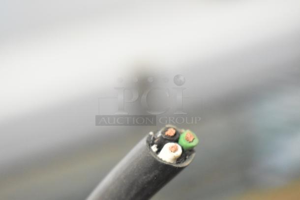 Close-up of a cable with three exposed wires: black, white, and green. Part of the 2 WD West Durable LED Vapor Tight Light.