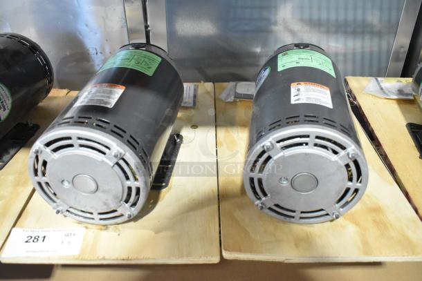 2 US Motors FK75 condenser fan motors, 208-230/460V, 3-phase, mounted on wooden base, visible labels and cooling vents.