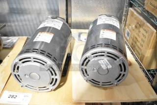 2 US Motors FK75 condenser fan motors, 208-230/460 volts, 3 phase, with labels detailing specifications and warnings.