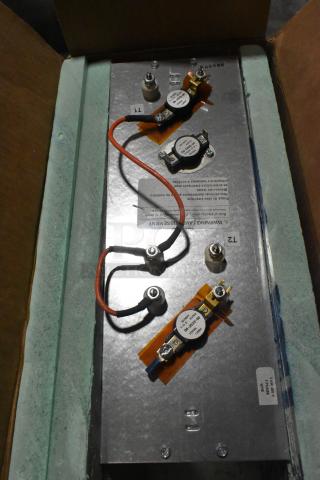 Metal box with attached wiring and components in cardboard packaging, showing labels and connectors, in excellent condition.