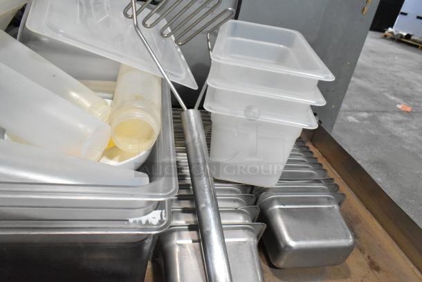 Lot of stainless steel and poly drop-in bins, various sizes, with plastic bottles and metal wire utensils included.