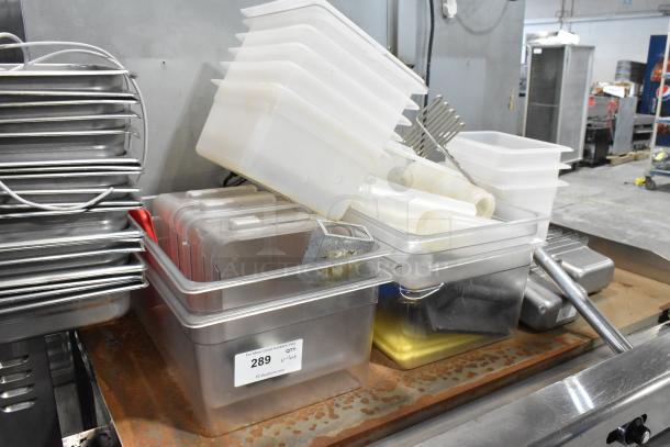 Lot of stainless steel and poly drop-in bins, various sizes, used condition. Label reads "289 Lot" by PCI Auctions.