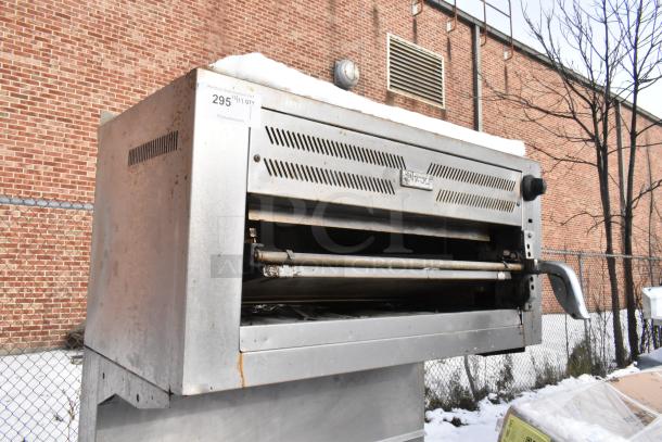 Wolf stainless steel salamander cheese melter, part of 10 burner commercial range. Visible rust, outdoor setting, auction tag 295.