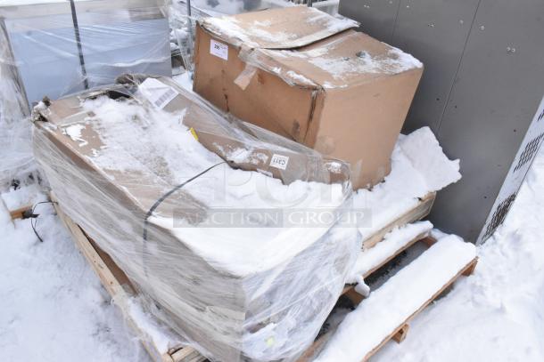 Pallet with two sealed cardboard boxes, snow-covered, labeled "427TBCLRD337." Items are new, scratch and dent condition.