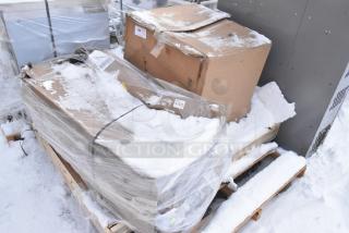 Pallet with two sealed cardboard boxes, snow-covered, labeled "427TBCLRD337." Items are new, scratch and dent condition.