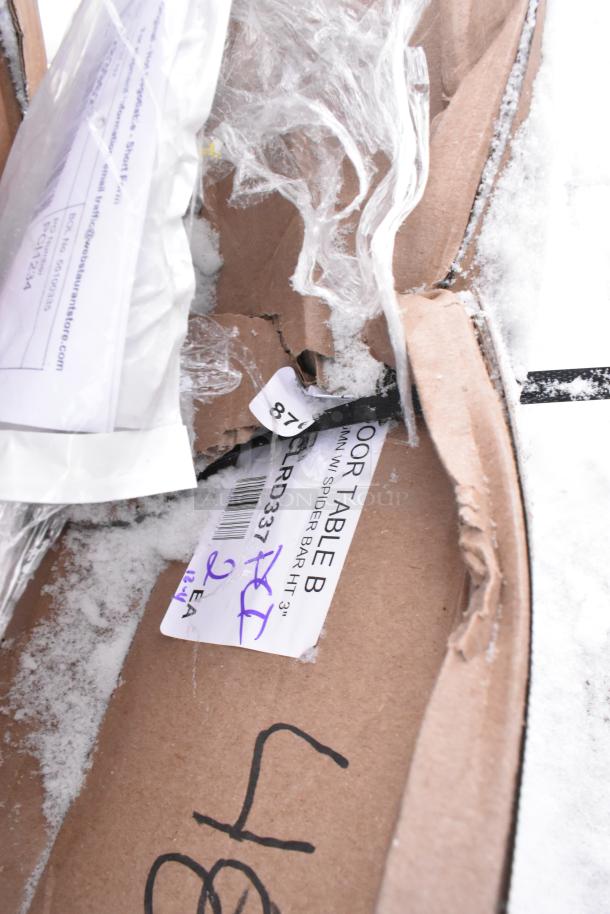 2 brand new Lancaster Table & Seating Excalibur 3" bar height table base columns, model 427TBCLRD337, in original packaging with minor scratches and dents visible.